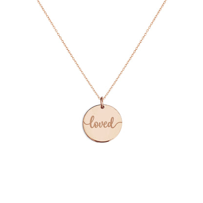 Solid rose gold necklace with a round pendant engraved with the word 'loved' on a white background