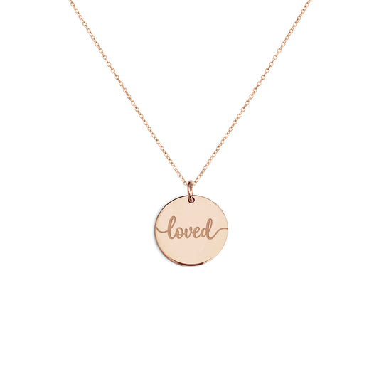 Solid rose gold necklace with a round pendant engraved with the word 'loved' on a white background