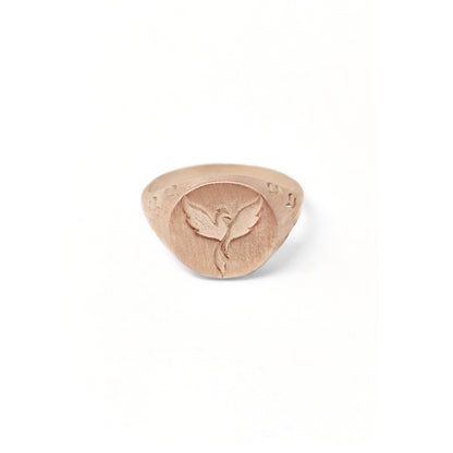 solid rose gold matte round signet ring engraved with a phoenix firebird rising with flame cutouts around the base of the ring's head