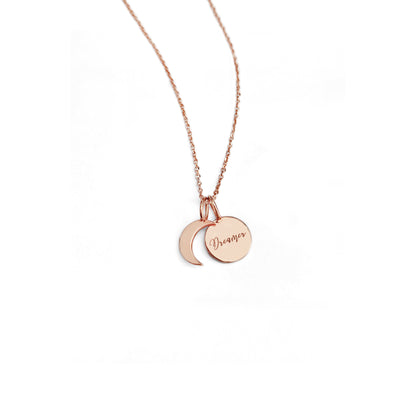 solid rose gold necklace with two small charms, a crescent moon and a personalized disc