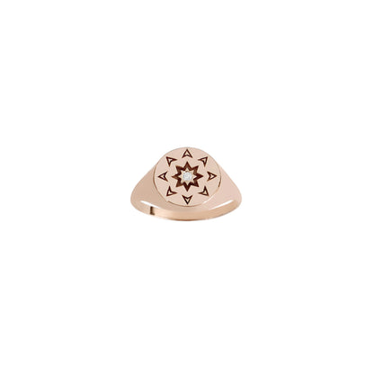 front view of a solid rose gold round signet ring with a north star starburst design and a diamond on the center