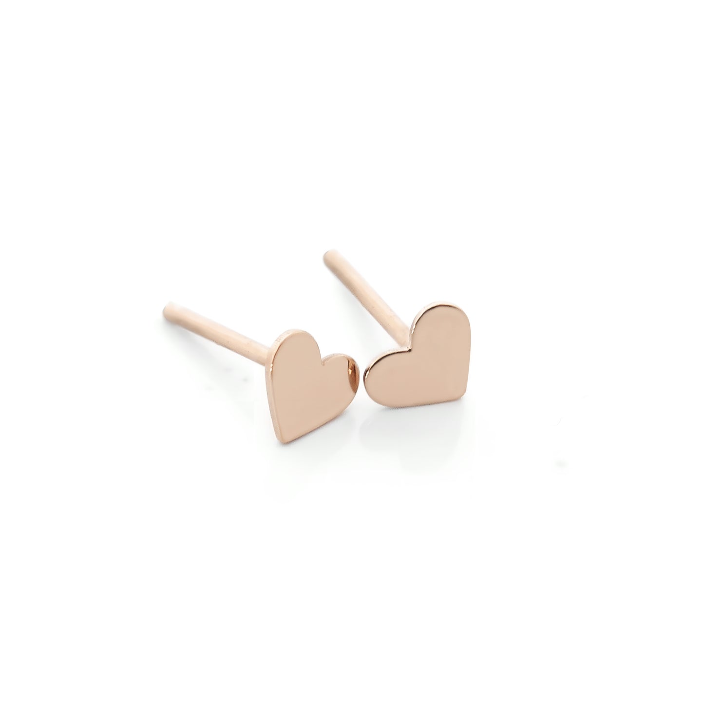 a pair of solid rose gold hear-shaped stud earrings