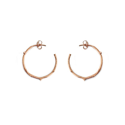 pair of solid rose gold hoop earrings with a twig branch like design