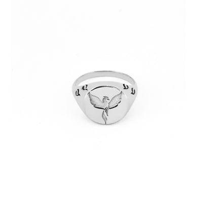 solid white gold polished round signet ring engraved with a phoenix firebird rising with flame cutouts around the base of the ring's head