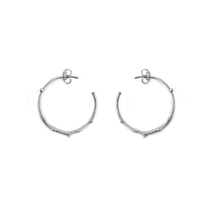 pair of solid white gold hoop earrings with a twig branch like design