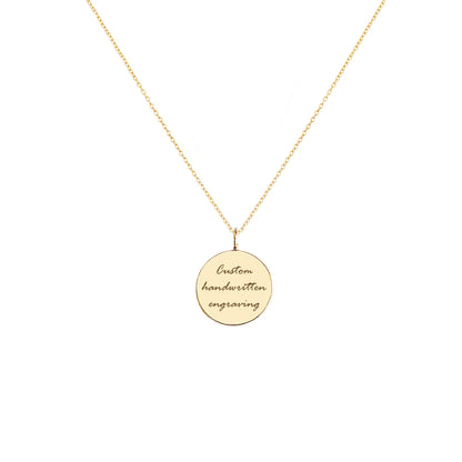 Gold necklace with a round pendant with handwritten engraving on a white background