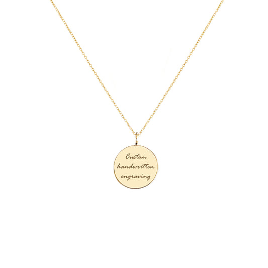 Gold necklace with a round pendant with handwritten engraving on a white background