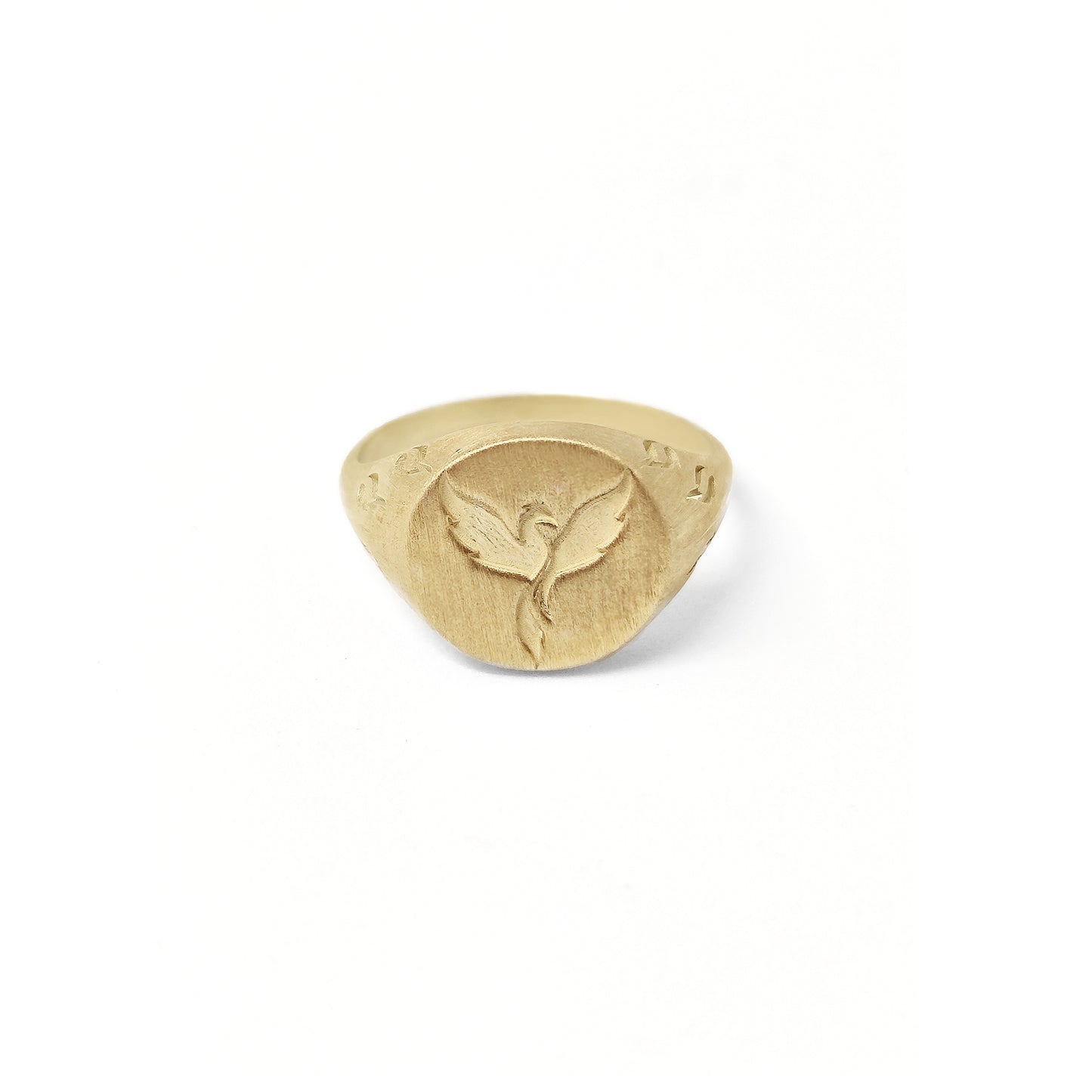 solid yellow gold matte round signet ring engraved with a phoenix firebird rising with flame cutouts around the base of the ring's head