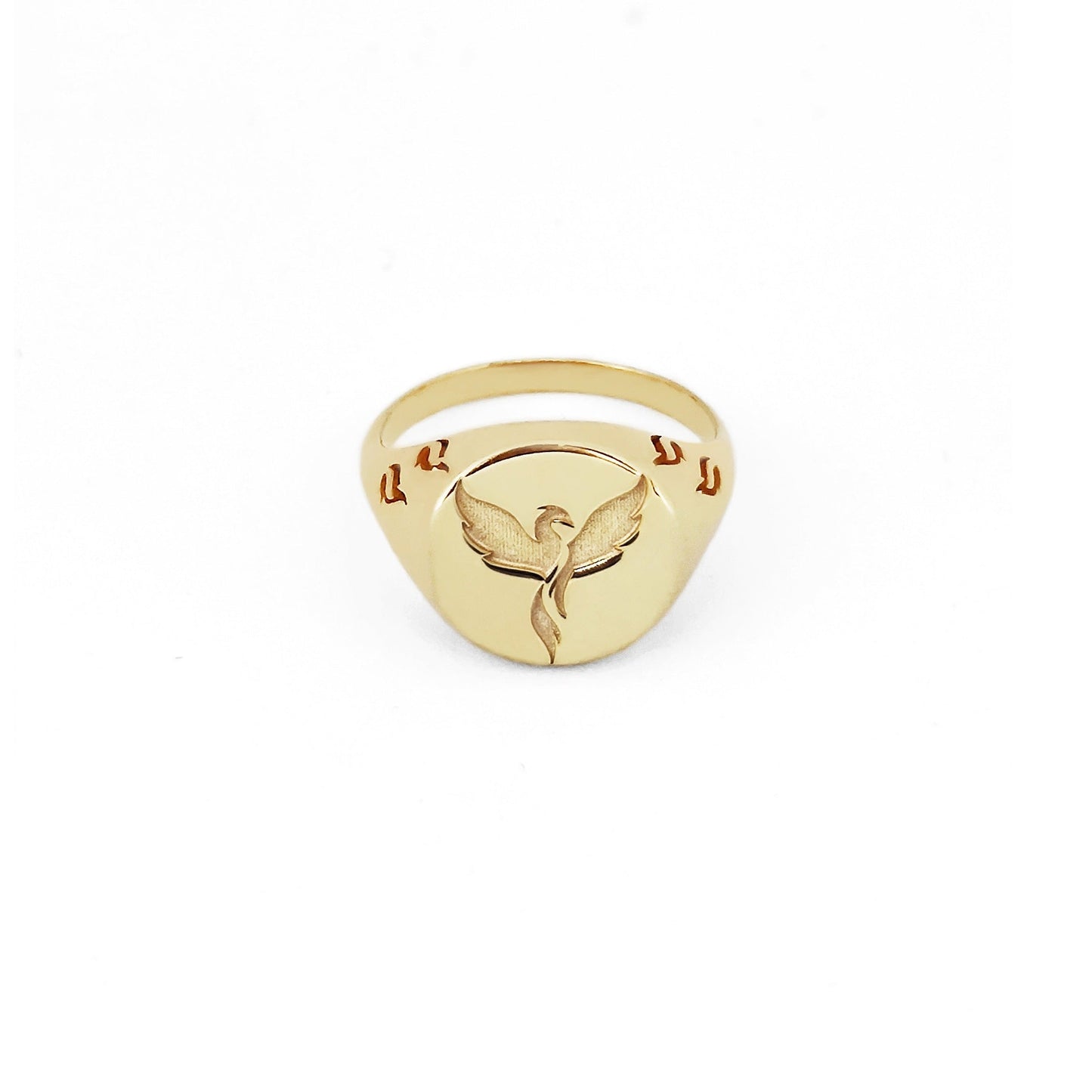 solid yellow gold polished round signet ring engraved with a phoenix firebird rising with flame cutouts around the base of the ring's head