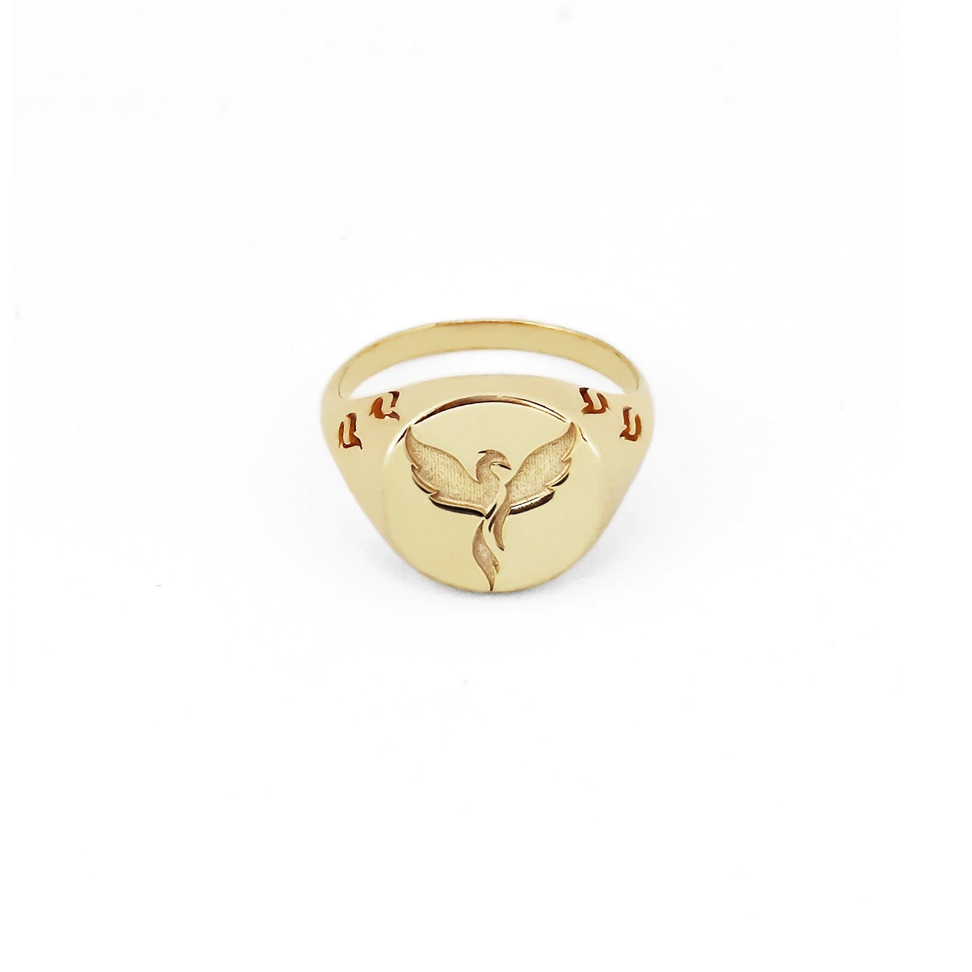 solid yellow gold polished round signet ring engraved with a phoenix firebird rising with flame cutouts around the base of the ring's head