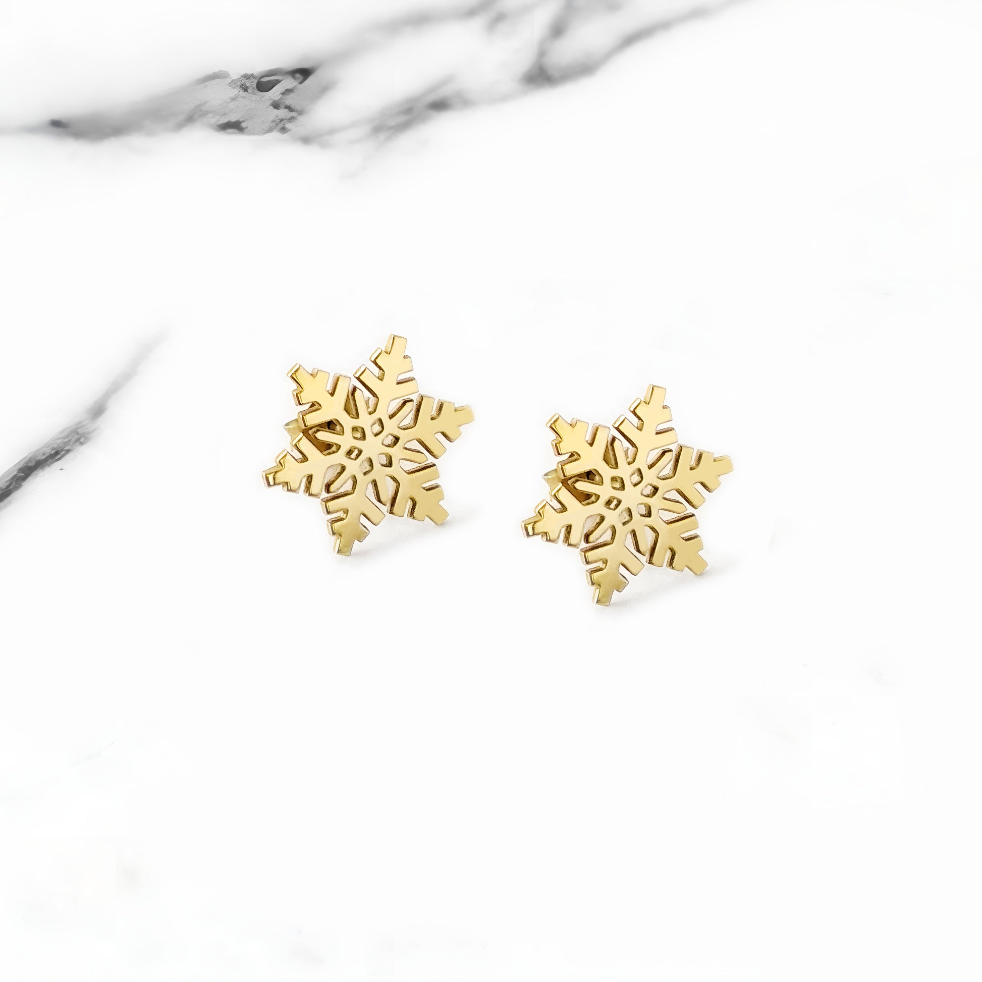 yellow gold stud earrings in the shape of snowflakes