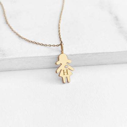 yellow gold necklace with tiny girl outline charm engraved with a monogram and set with tiny diamond