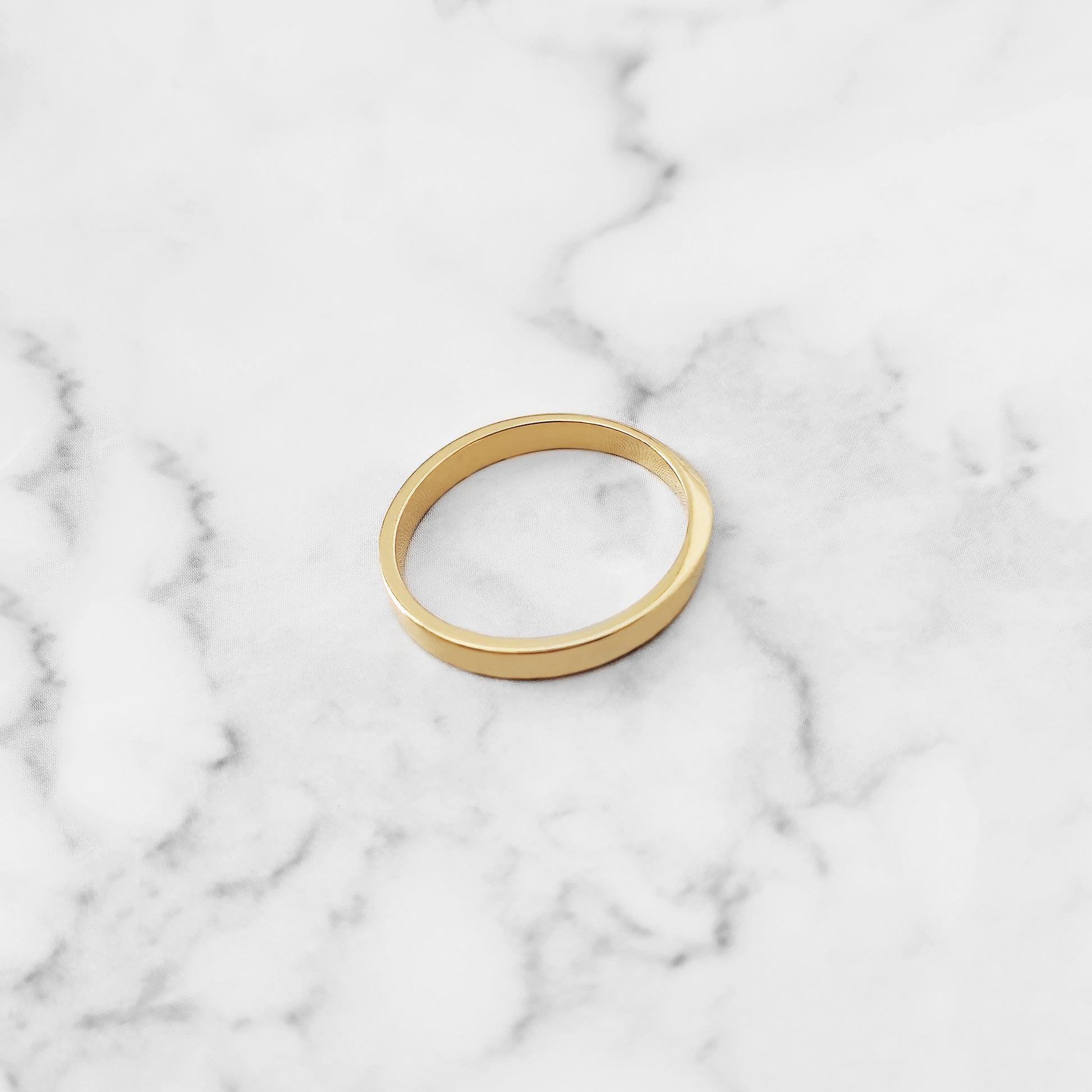 top view of a solid yellow gold thin mobius wedding ring 
