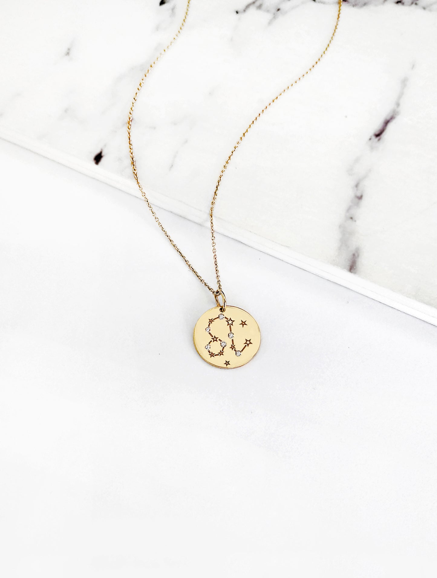 gold necklace with a 14mm disc pendant engraved with the Leo zodiac sign and set with six tiny diamonds