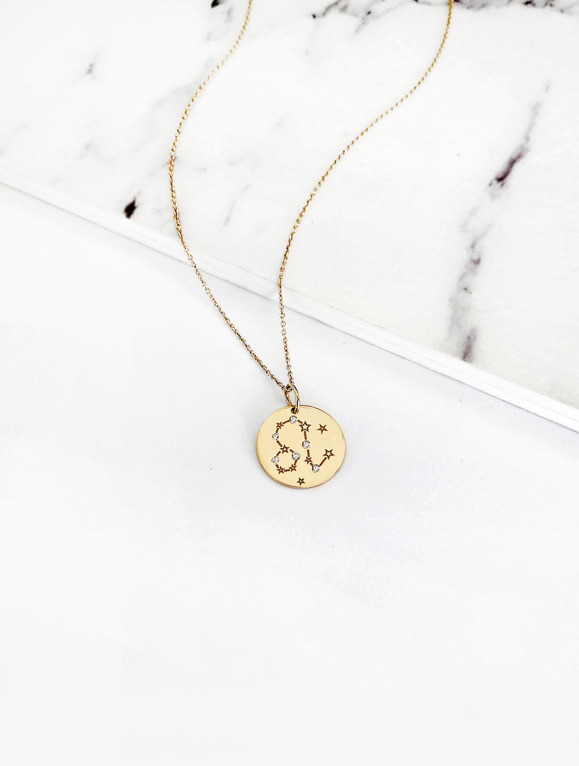 gold necklace with a 14mm disc pendant engraved with the Leo zodiac sign and set with six tiny diamonds