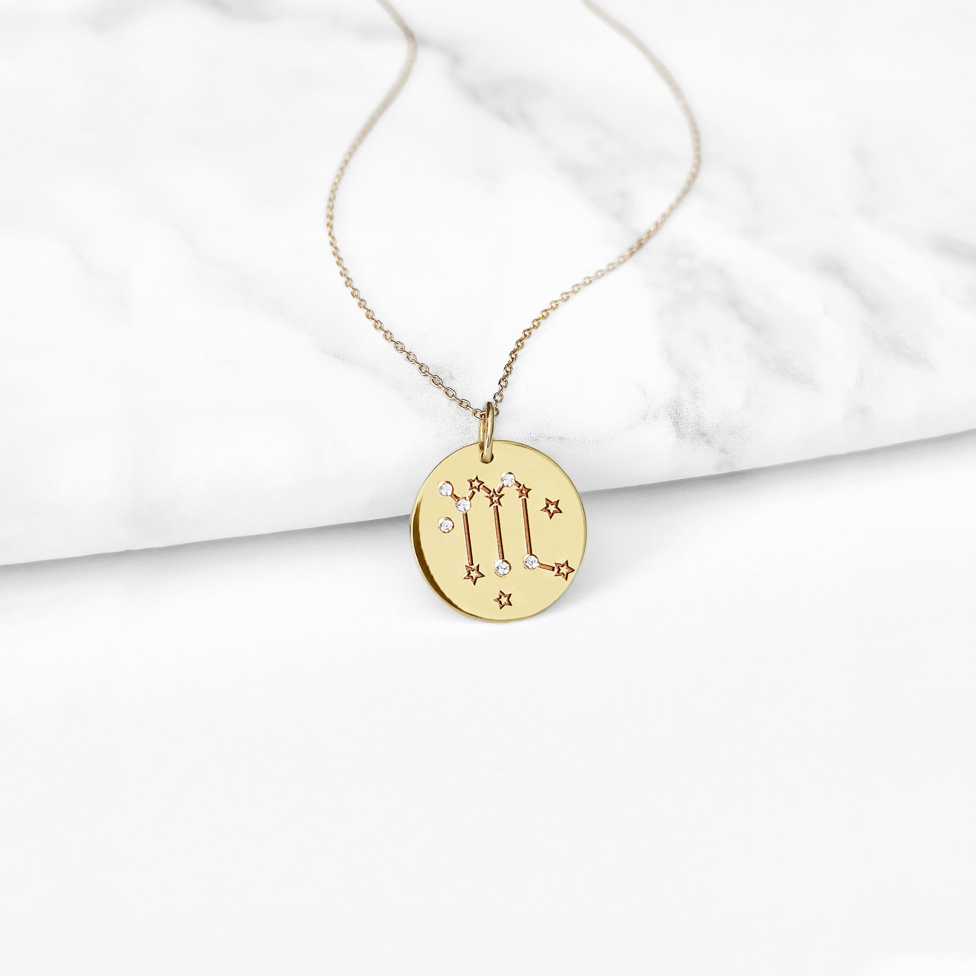 gold necklace with a 14mm disc pendant engraved with the scorpio zodiac sign and set with six tiny diamonds