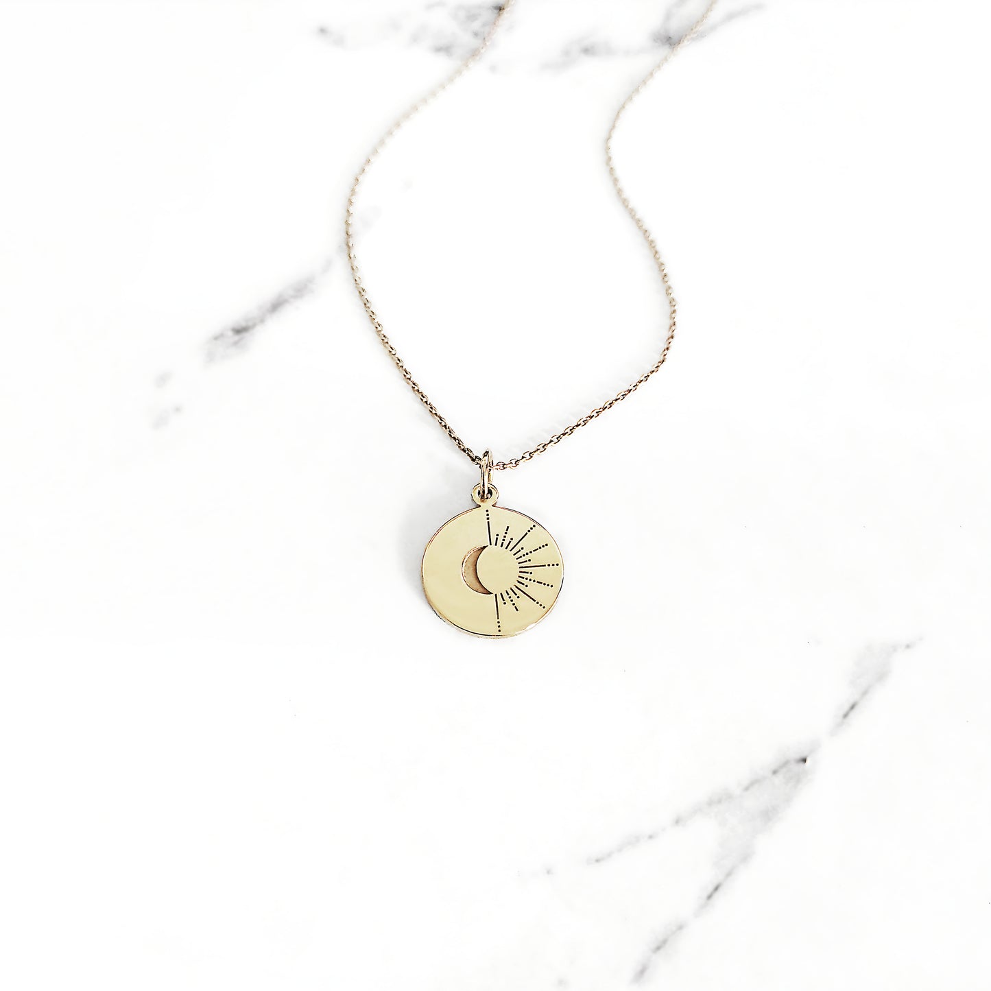 yellow gold disc pendant necklace engraved with a crescent moon and sun rays