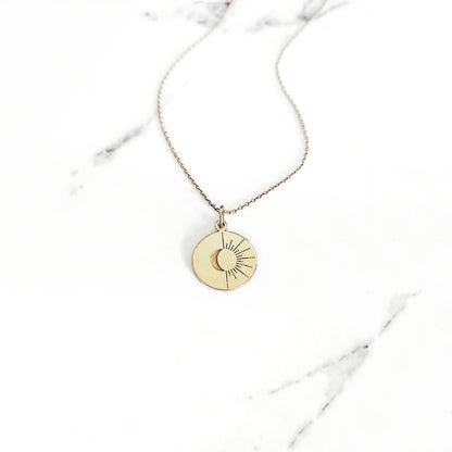 yellow gold disc pendant necklace engraved with a crescent moon and sun rays