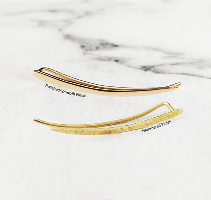 close up of two solid yellow gold climber earrings one with a polished smooth finish and the other with a polished finish